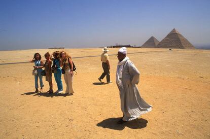 Un grupo de turistas frente a las pirámides de Giza, en El Cairo (Egipto).