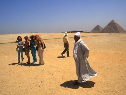 Un grupo de turistas frente a las pirámides de Giza, en El Cairo (Egipto).