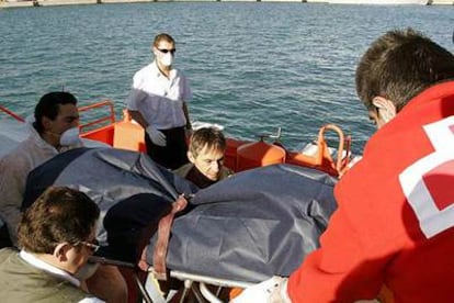 Miembros de Cruz Roja transportan el cadáver encontrado en la patera localizada cerca de Almería.