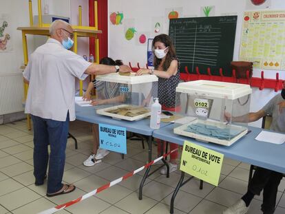 Un elector deposita su voto en un colegio de Marsella.