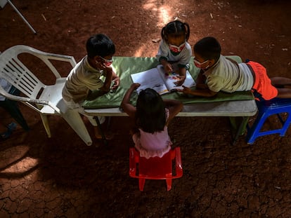 Niños indígenas emberá consultan un libro durante las clases en su comunidad en marzo de 2021, en Panamá.