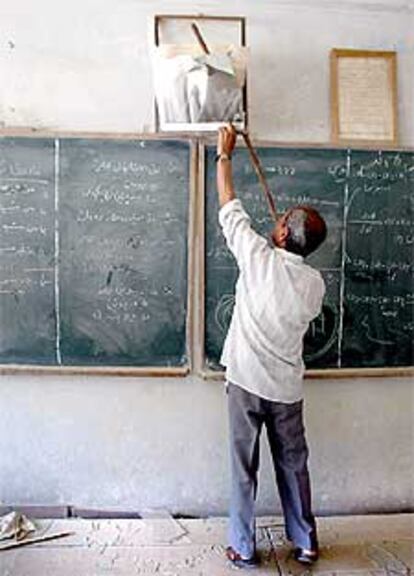 El profesor de química Yassin Mujbil rompe una fotografía de Sadam, ayer en una escuela de Basora.