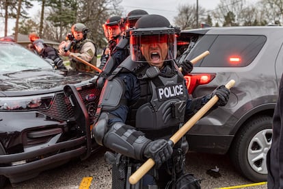 Policía se ponen a cubierto frente a manifestantes después de que un agente disparó y mató a un hombre negro en el Brooklyn Center, Minneapolis, Minnesota.