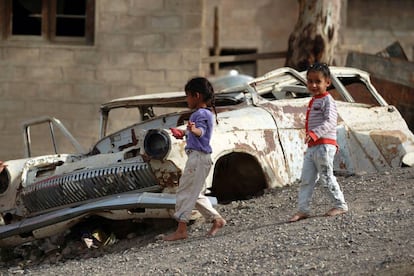 Niños juegan cerca de un coche en Saná, la capital de Yemen