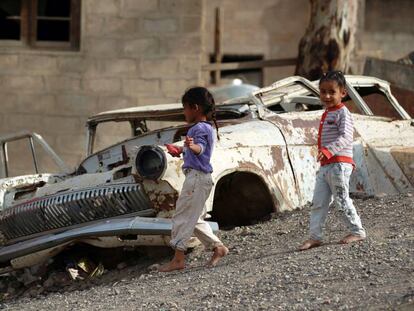 Niños juegan cerca de un coche en Saná, la capital de Yemen