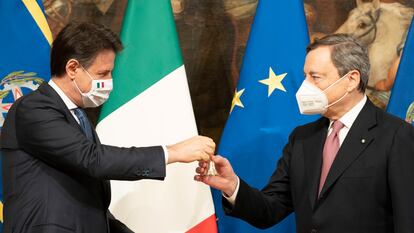 El nuevo primer ministro, Mario Draghi, recibe de su predecesor, Giuseppe Conte, una campanilla de plata como símbolo del traspaso de poderes, este sábado en Roma.