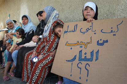 Una desplazada en una escuela de Beirut, con un cartel en el que se lee: "¿Cómo puede la paz nacer de las llamas?".