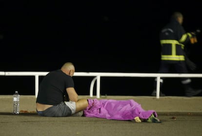 Un hombre sentado al lado de un cuerpo.