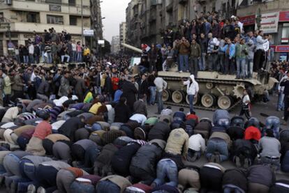 Manifestantes antigubernamentales rezan ante un tanque del Ejército en la plaza Tahrir, ayer en El Cairo.
