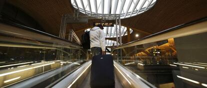 Un pasajero sube con un trolley por la rampa automática de la T- 4 del aeropuerto de Madrid- Barajas.