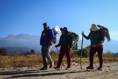 Peregrinos caminan frente al volcán Iztaccíhuatl hacia Ciudad de México. 