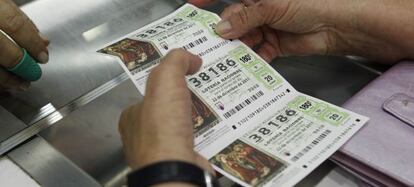 Una mujer compra décimos para el sorteo de Navidad en una administración de lotería.