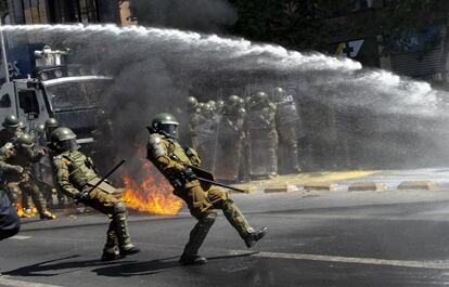 Un cóctel molotov explota frente a la policía antidisturbios durante una protesta, en el centro de Santiago (Chile).