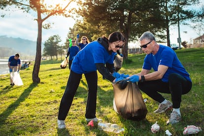 Voluntarios recogiendo basura en el entorno de un río.