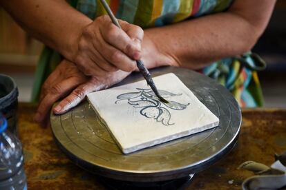 Cristina Pina dibujando encima de un azulejo en su taller.