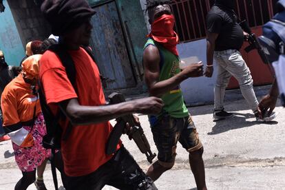 Hombres armados en la marcha organizada por Jimmy 'Barbecue' Cherizier, líder de la coalición de bandas que controla el 80% de Puerto Príncipe (según estimaciones de la ONU), en el barrio de Delmas, el 10 de mayo. En junio llegó a Haití el primer contingente de una fuerza internacional respaldada por la ONU para reforzar los servicios de seguridad del país, que carecen de recursos suficientes, y policías kenianos empezaron a patrullar la capital.