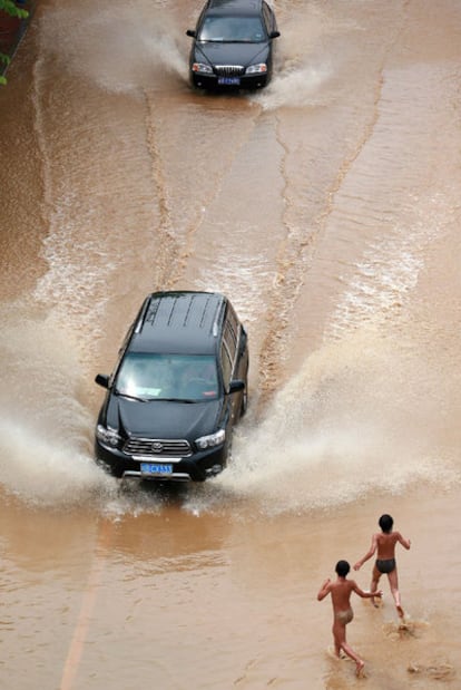 Unos niños juegan en una calle inundada al sur de China