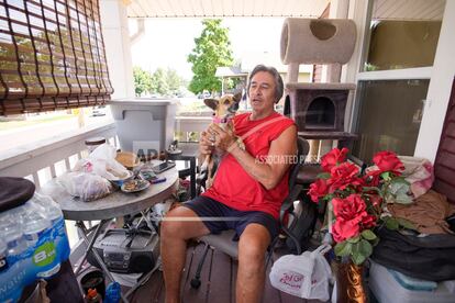 Ben Gallegos sits on the porch of his family's home in the Globeville neighborhood with his dog, Coca Smiles, as the daytime high temperature soars toward triple digits, on July 27, 2023, in Denver.