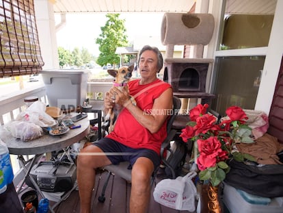 Ben Gallegos sits on the porch of his family's home in the Globeville neighborhood with his dog, Coca Smiles, as the daytime high temperature soars toward triple digits, on July 27, 2023, in Denver.