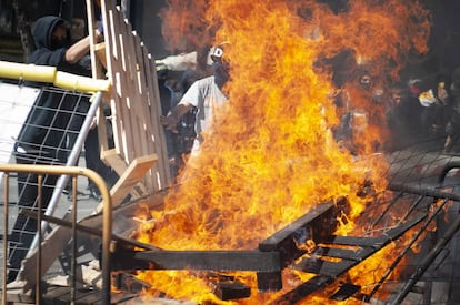 Varios manifestantes independentistas queman una barricada durante el acto de Vox en Barcelona.