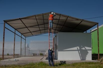 Trabajadores instalan luces de energía solar en la cooperativa.