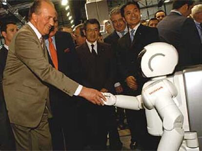 El rey Juan Carlos I saluda a Asimo, el robot humanoide de Honda.