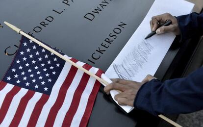 Una mujer graba el nombre de una amiga que murió en los ataques contra el World Trade Center en Nueva York, durante la ceremonia del aniversario de los atentados.