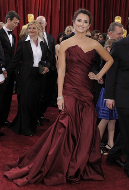 La actriz española, candidata al Oscar a la mejor interpretación de reparto, ha optado por un vestido hasta los pies granate de Donna Karan. Fiel a su estilo, Penélope luce un escote palabra de honor con un orginal corte y lleno de pliegues. La actriz lleva un sencillo recogido, que combina adecuadamente con el traje.