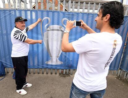 Un aficionado se fotografía junto a una imagen de la copa de Europa cerca del estadio Cardiff City. 