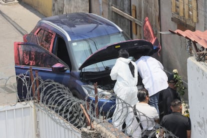 Peritos investigan un auto vinculado al crimen.