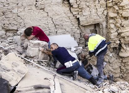 Residentes del pueblo de Amatrice ayudan a las víctimas entre los edificios destruidos.