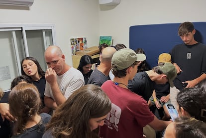 Assaf Sade (con camiseta blanca) se protege el jueves junto a familiares y amigos en la habitación de seguridad de su casa del norte de Israel durante un ataque de Hezbolá durante el duelo por la muerte de su hijo Sivan, de 18 años, que perdió la vida el día antes por el impacto de un proyectil de la milicia libanesa.