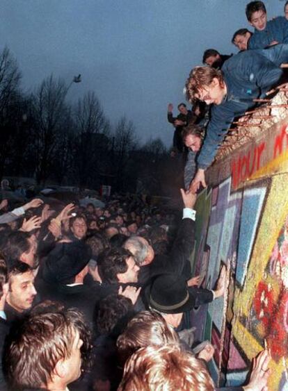 El canciller alemán Helmut Kohl estrecha la mano de un ciudadano berlinés  encaramado en lo alto del Muro de Berlín, cerca de la Puerta de Brandenburgo, el 22 de diciembre de 1989.
Foto: EFE
