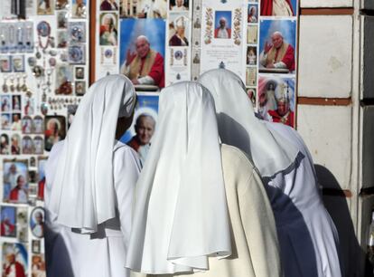 Unas monjas ante un quiosco de venta de recuerdos religiosos en el entorno de la Plaza de San Pedro, donde se celebrará la ceremonia de santificación.