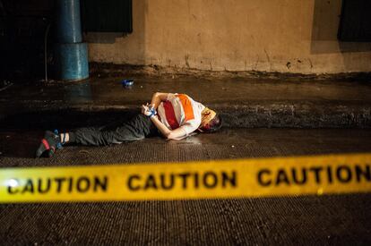 Una víctima de una ejecución sumaria yace muerto en la calle con la boca tapada con cinta de embalaje en Manila (Filipinas).