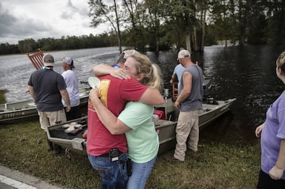 Una familia se abraza mientras retira las pertenencias de su casa inundada en Trenton, Carolina del Norte.