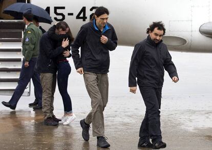 Los periodistas españoles Ángel Sastre (d), José Manuel López (c) y Antonio Pampliega (i, abrazando a un familiar), a su llegada esta mañana a la Base äerea de Torrejón de Ardoz, en Madrid, tras ser liberados ayer en Siria.