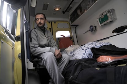 El palestino Samy Al Bahnasawy junto al cuerpo de su mujer, fallecida en el hospital de Egipto a causa de las heridas provocadas por la guerra, mientras cruzan la frontera de Rafah de vuelta a Gaza, este lunes.