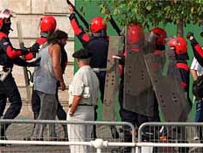 La Ertzaintza insta a uno de los participantes en la protesta frente al Ayuntamiento de Bilbao a abandonar el lugar.