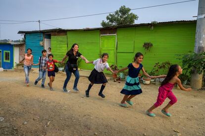 La primera vez que fotografié a Mayerly Sánchez, en 1998, iba de la mano de una fila de niños, marchando por un barrio marginado de Bogotá. Como apasionada niña apadrinada de 14 años, codirigió valientemente un movimiento de paz infantil que fue nominado para el Premio Nobel de la Paz. Ahora, 21 años después, Mayerly, a la que podéis ver en la foto con el polo negro, es gerente de comunicaciones de World Vision en Colombia. Y nuevamente me sorprendo al encontrarla en la misma situación: de la mano de los niños y niñas en una comunidad afectada por la crisis de Venezuela.