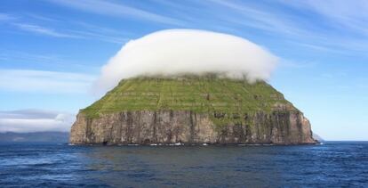 La peque&ntilde;a isla rocosa Litla D&iacute;mun, en las islas Feroe, con un sombrero de nubes. 