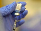 A pharmacist prepares a syringe of the Pfizer-BioNTech COVID-19 vaccine Friday, Jan. 8, 2021, at Queen Anne Healthcare, a skilled nursing and rehabilitation facility in Seattle. Pfizer has committed to supply up to 40 million doses of its COVID-19 vaccine this year to a World Health Organization-backed effort to get affordable vaccines to 92 poor and middle-income countries. The deal announced Friday, Jan. 22 will supply the shots to the program known as COVAX.   (AP Photo/Ted S. Warren)