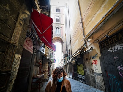 Una mujer con una mascarilla camina por el desértico centro de Nápoles este lunes.