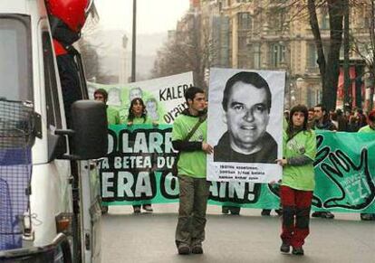 Un furgón de la Ertzaintza sigue de cerca la cabecera de la marcha en la que decenas de personas reivindicaron el día 20 de enero, por la Gran Vía de Bilbao, los derechos de los presos de ETA y la puesta en libertad del preso Iñaki de Juana Chaos (fotografía del cartel), en huelga de hambre.