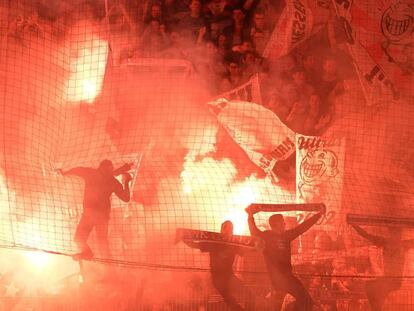 Aficionados del Stuttgart encienden bengalas durante el encuentro de la segunda etapa de la Bundesliga frente al Union Berlin, en el Estadio An der Alten Försterei, en Berlín (Alemania).