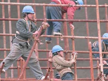 Trabajadores chinos montan una estructura metálica.