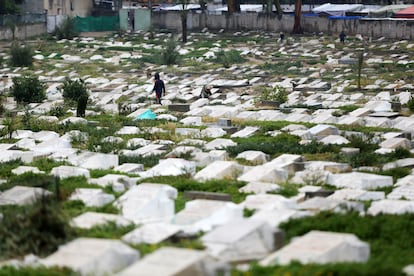 Familiares de palestinos lloran ante las tumbas de sus seres queridos, en el cementerio después de la oración de Eid al-Fitr mientras continúan los ataques israelíes en Deir Al Balah.