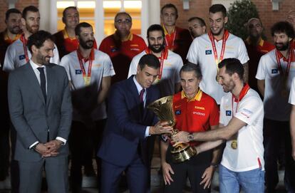 El presidente del Gobierno en funciones Pedro Sánchez  recibe la copa de manos del capitán de la selección española de baloncesto Rudy Fernández (derecha), acompañados por el seleccionador nacional Sergio Scariolo (segundo por la derecha) y por el presidente de la Federación Jorge Garbajosa (izquierda), durante la audiencia que ofrece al combinado español, que ayer se proclamó campeona del Mundial de Baloncesto 2019 en Pekín, hoy lunes en el Palacio de la Moncloa.  