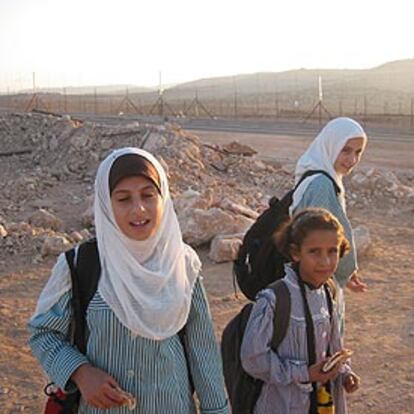 Tres niñas palestinas de Jubara, cerca del muro que han de cruzar para acudir a la escuela.