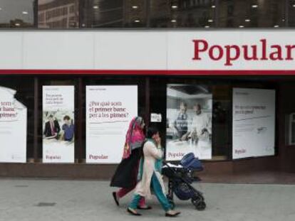 Unas mujeres pasan ante una oficina del Banco Popular en Barcelona. EFE/Archivo